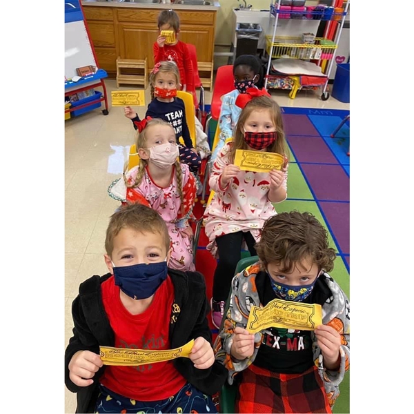 Preschool students holding up tickets for the Polar Express