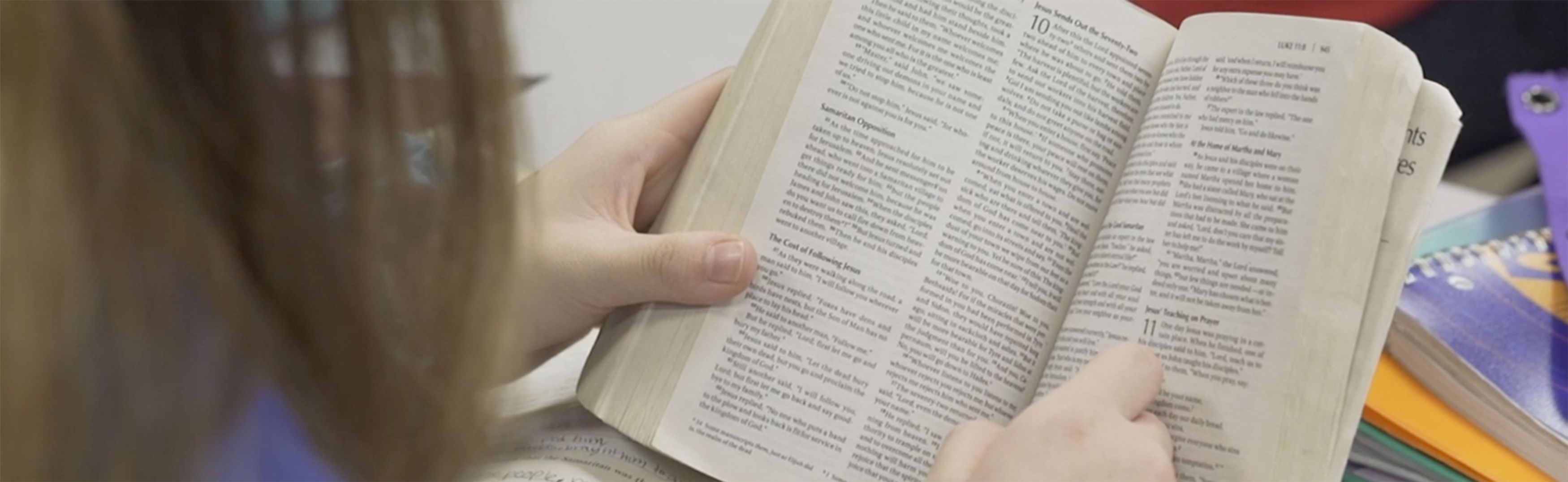 Student reading her Bible in class